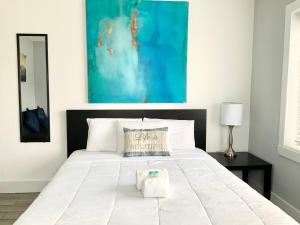 - une chambre avec un grand lit blanc orné d'une peinture bleue dans l'établissement Adorable private apartments in the Heart of Miami!, à Miami