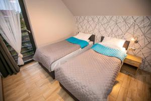 2 łóżka pojedyncze w pokoju z oknem w obiekcie Apartamenty PIER w Stegnie