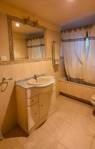 La salle de bains est pourvue d'un lavabo, d'un miroir et d'une baignoire. dans l'établissement Casarural Vallecillo, à Vallecillo