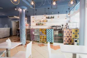 a restaurant with a kitchen with tables and chairs at Villaggio Hemingway - Family Aparthotel in Caorle