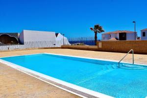 une grande piscine bleue dans une cour dans l'établissement 2BDR Ocean view apartment, à Poris de Abona