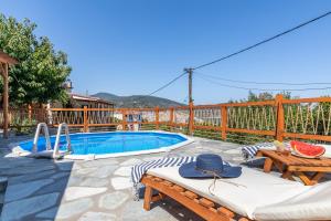 un patio con piscina, mesa y sillas en Villa Watermill, en Skopelos Town