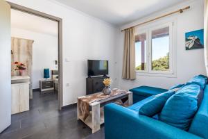 sala de estar con sofá azul y mesa en Villa Watermill, en Skopelos Town