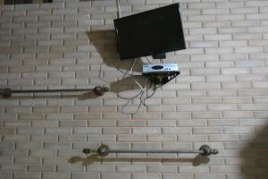 a tv on a brick wall with a camera at Pousada Mar Azul in Trindade