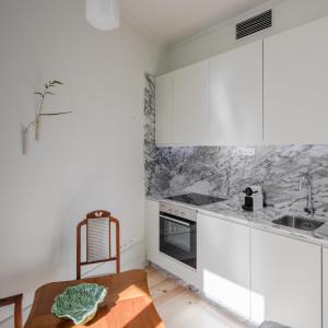 eine Küche mit weißen Schränken und einem Holztisch in der Unterkunft Oporto Cozy & Comfy in Porto