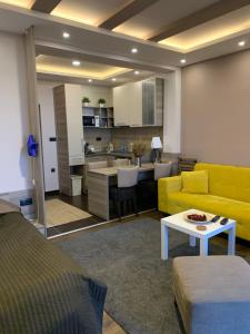 a living room with a yellow couch and a kitchen at Milmari Mountain view - I11 in Kopaonik +30 photos