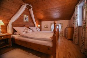 - une chambre avec un grand lit à baldaquin dans l'établissement Landhaus Binder, à Samerberg