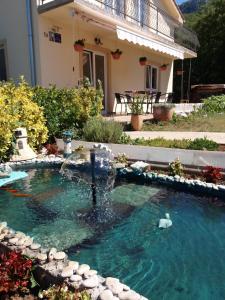 a swimming pool with a fountain in front of a house at Ignac Tribalj in Tribalj