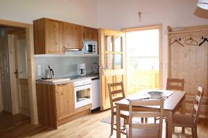 a kitchen with a table and a kitchen with a table and chairs at Rieplhof in Samerberg