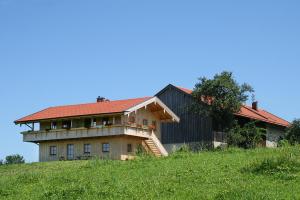 ein Gebäude mit rotem Dach auf einem Hügel in der Unterkunft Rieplhof in Samerberg