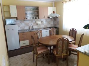 a kitchen with a table and chairs and a kitchen with a refrigerator at Ignac Tribalj in Tribalj