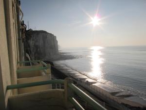 una vista del océano con un sol brillando sobre el agua en Le COURLIS vue panoramique sur la mer, balcons, en Ault