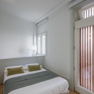Habitación blanca con cama y ventana en Oporto Cozy & Comfy, en Oporto
