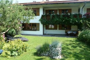 a house with a yard with plants and flowers at Ferienwohnung Kathi in Samerberg