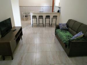 een woonkamer met een bank en een televisie bij Casa em Unamar 3 Cabo Frio RJ in Tamoios