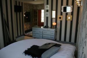 a bed in a room with a white bedspread at Le Parvis in Chartres