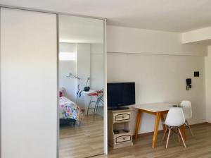 ブエノスアイレスにあるUN ESPACIO MODERNO EN CABALLITOのベッドルーム(鏡、テーブル、ベッド付)