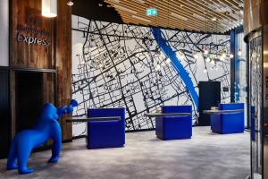 a blue bear standing in front of a wall with a map at Holiday Inn Express - Warsaw - The HUB, an IHG Hotel in Warsaw