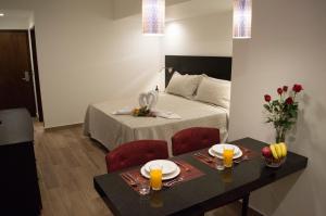 a bedroom with a bed and a table with two chairs at Suites Terraza Imperial in Guatemala