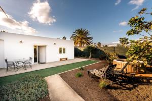 ein weißes Haus mit einer Terrasse und einer Liegewiese in der Unterkunft Apto. Aica Maraga (Aeropuerto) in Ojos de Garza