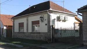uma casa branca com um telhado preto e uma cerca em Vazsita ház em Erdobénye