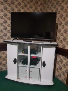 a flat screen tv on top of a white entertainment center at Gite l'Escale in Gigny-sur-Saône