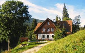 une maison assise au sommet d'une colline verdoyante dans l'établissement Pension Fontana, à Špindlerův Mlýn