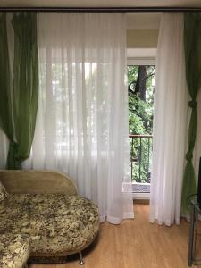 a bedroom with a bed and a large window at Kyiv Apartment in Pechersk on Oleksandra Kopylenko in Kyiv