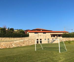 een veld met een doel voor een gebouw bij Quinta do Ovelheiro in Guimarães