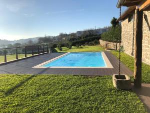 a swimming pool in a yard next to a house at Quinta do Ovelheiro in Guimarães