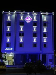 un grande edificio con un edificio illuminato di blu di ابيات ميرا a Abha