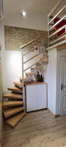 una escalera de madera con una pizarra en una habitación en Zona Apartments 1, en Zrenjanin