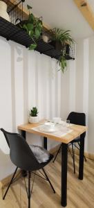 una sala da pranzo con tavolo e sedie in legno di Zona Apartments 1 a Zrenjanin