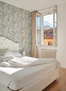 a bedroom with a white bed and a window at Lainez Rooms & Suites in Trento