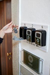 a person is holding a key to a door at Lainez Rooms & Suites in Trento