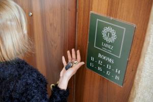 a woman is unlocking a door with her hand at Lainez Rooms & Suites in Trento