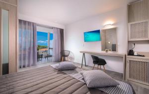 - une chambre avec un lit et un bureau avec vue dans l'établissement Lagomandra Beach Hotel, à Lagomandra