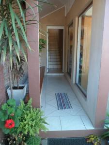 un pasillo de una casa con plantas y escaleras en Estrelatto Residence, en Gramado