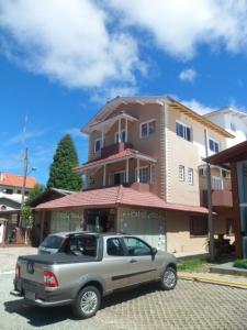 a silver suv parked in front of a building at Estrelatto Residence in Gramado