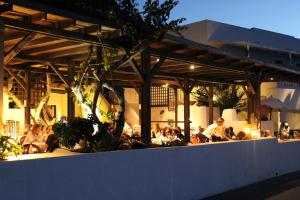 a group of people sitting outside a restaurant at night at La Sirenetta Park Hotel in Stromboli