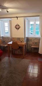 里斯本的住宿－Lisbon City Centre Apartment，一间带桌子和2个窗户的用餐室