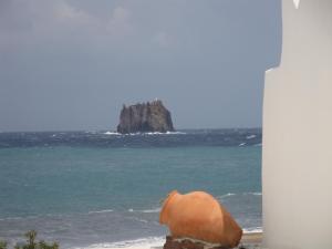 a rock in the ocean next to the beach at La Sirenetta Park Hotel in Stromboli