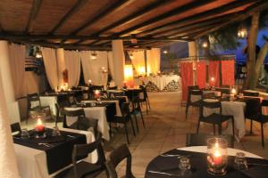 a restaurant with white tables and chairs and candles at La Sirenetta Park Hotel in Stromboli
