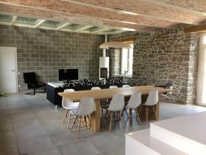 una sala da pranzo con tavolo, sedie e muro di mattoni di Classy Holiday Home in Achet with Garden 