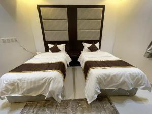 two beds sitting next to each other in a room at ابيات ميرا in Abha