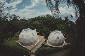 Duas tendas de yurt sentadas num deque num quintal em Hostel Da Vila Ilhabela em Ilhabela