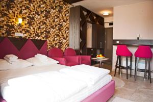 Habitación de hotel con 2 camas y sillas rosas en Apartman NERA - u Kraljevim čardacima Kopaonik, en Kopaonik 24 fotos más