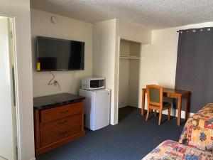 una camera d'albergo con TV a parete di Golden Hills Motel a Tehachapi