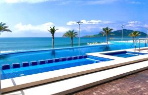 a swimming pool with the ocean in the background at Varali Grand Hotel in Mazatlán