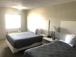 a hotel room with two beds and a window at BestWay Inn Oklahoma City Airport in Oklahoma City